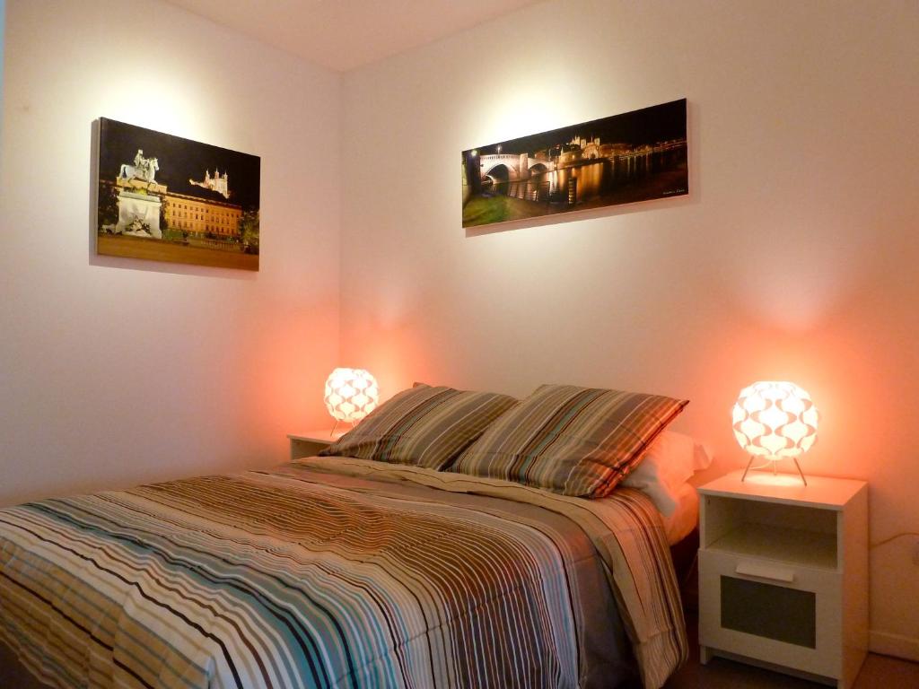 um quarto com uma cama com dois candeeiros em B&B "Clos Feuillat" em Lyon