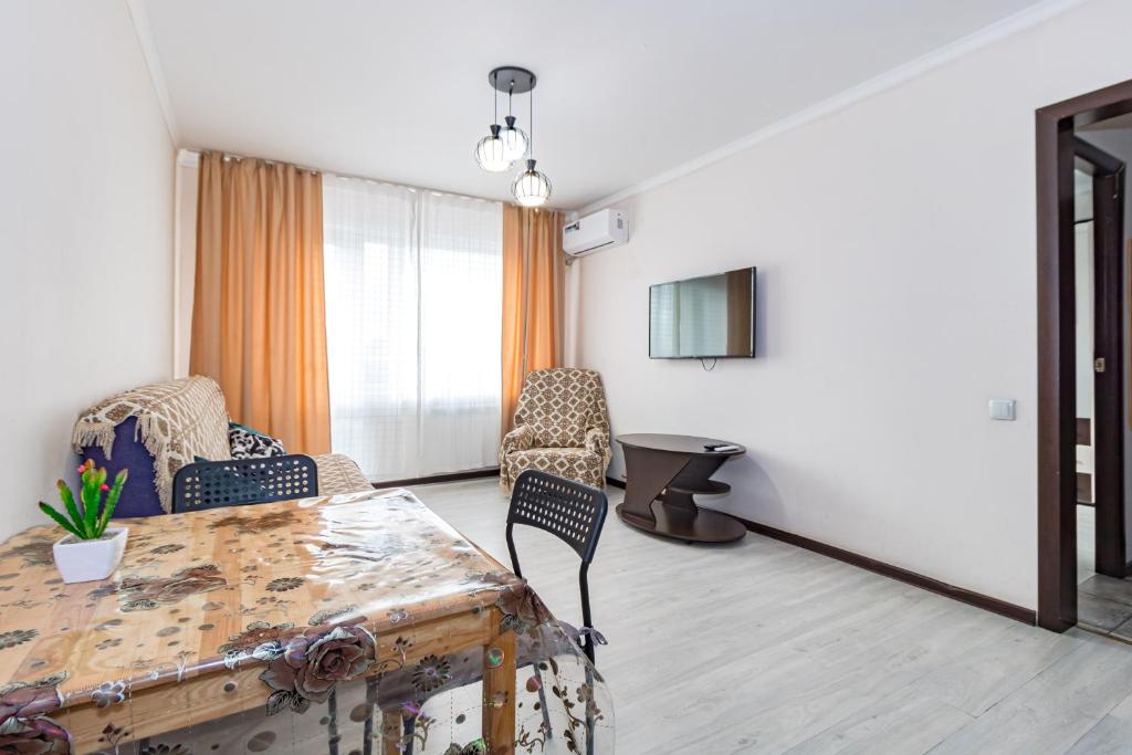a living room with a table and chairs at Уютная Евродвушка рядом с Центральной Мечетью in Pavlodar