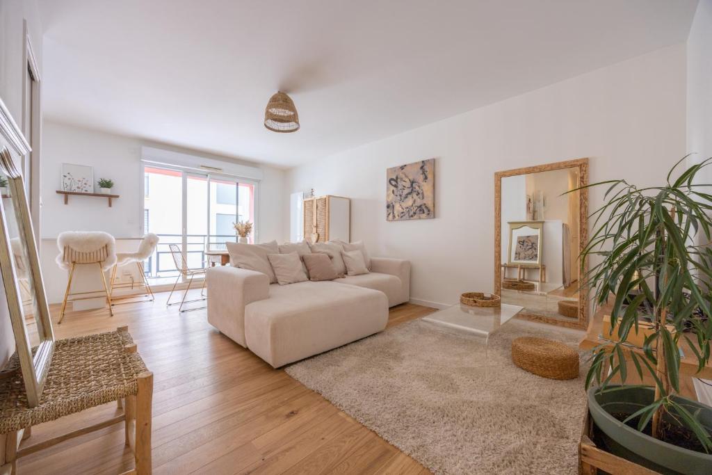 un salon avec un canapé blanc et une table dans l'établissement Mayence Parking Cité des Congrès 4pers Tv Wifi, à Nantes