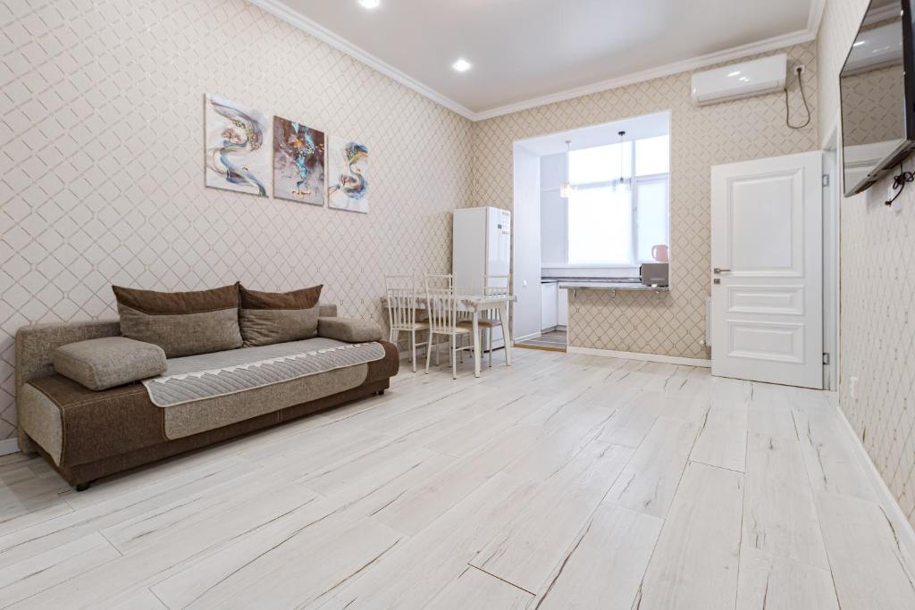 a living room with a couch and a table at Трех комнатные апартаменты в новом доме рядом с Батырмол in Pavlodar