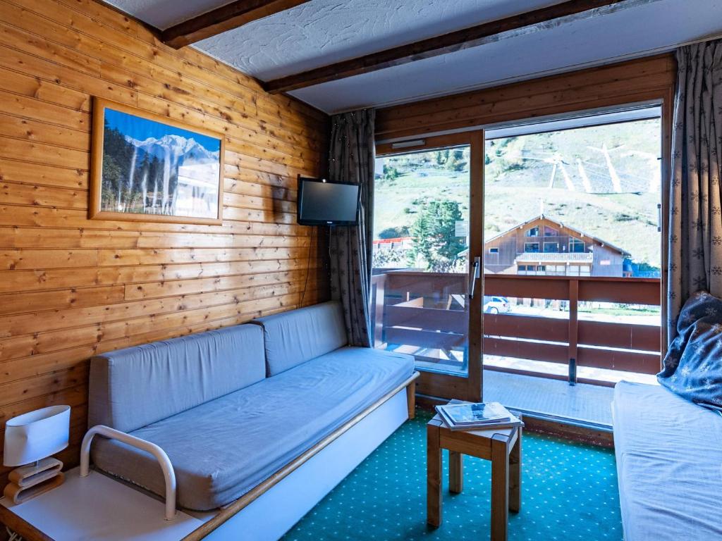 un salon avec un canapé et une fenêtre dans l'établissement Appartement à Méribel Mottaret - Pied des pistes, balcon, casier à skis - FR-1-355-88, à Méribel