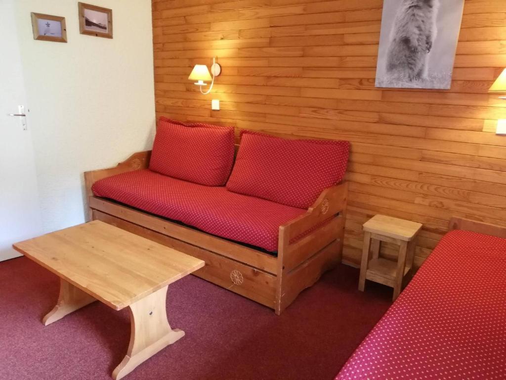 - un canapé avec des oreillers rouges dans l'établissement Charmant 2 pièces, skis aux pieds, balcon, à 50m télécabine, Crève Coeur Valmorel - FR-1-356-356, à Valmorel