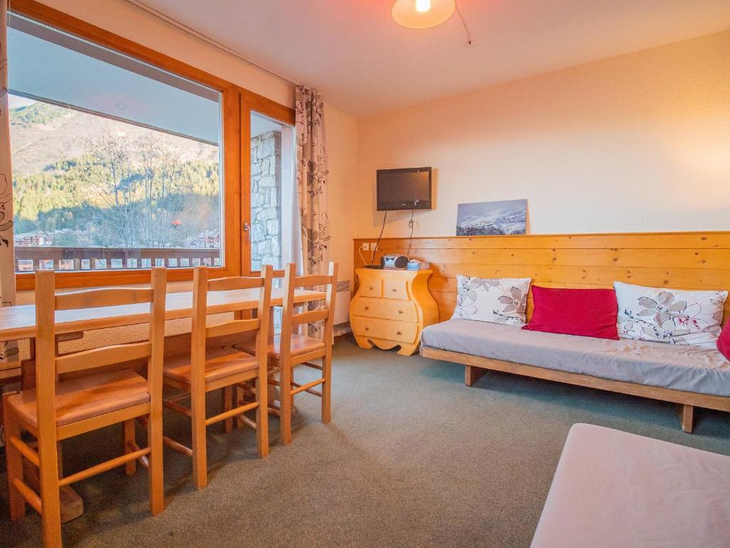Cette chambre comprend une table, un canapé et une fenêtre. dans l'établissement Valmorel - Appartement 2 pièces - 4 pers - Pieds des pistes - FR-1-356-203, à Valmorel