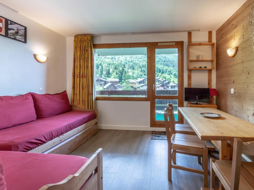 un salon avec un canapé rose et une table dans l'établissement Valmorel - Appart 2 pièces pour 5, au pied des pistes et commerces - FR-1-356-375, à Valmorel