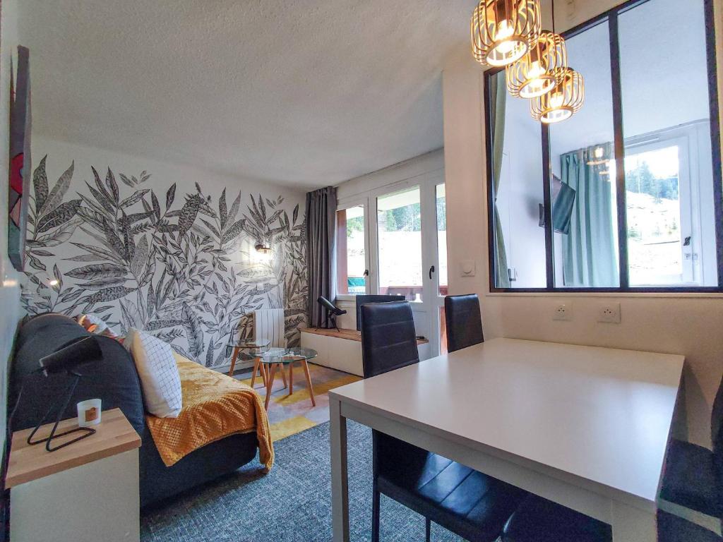 un salon avec un canapé et une table dans l'établissement Studio rénové au pied des pistes, balcon sud, commerces proches - FR-1-356-406, à Valmorel