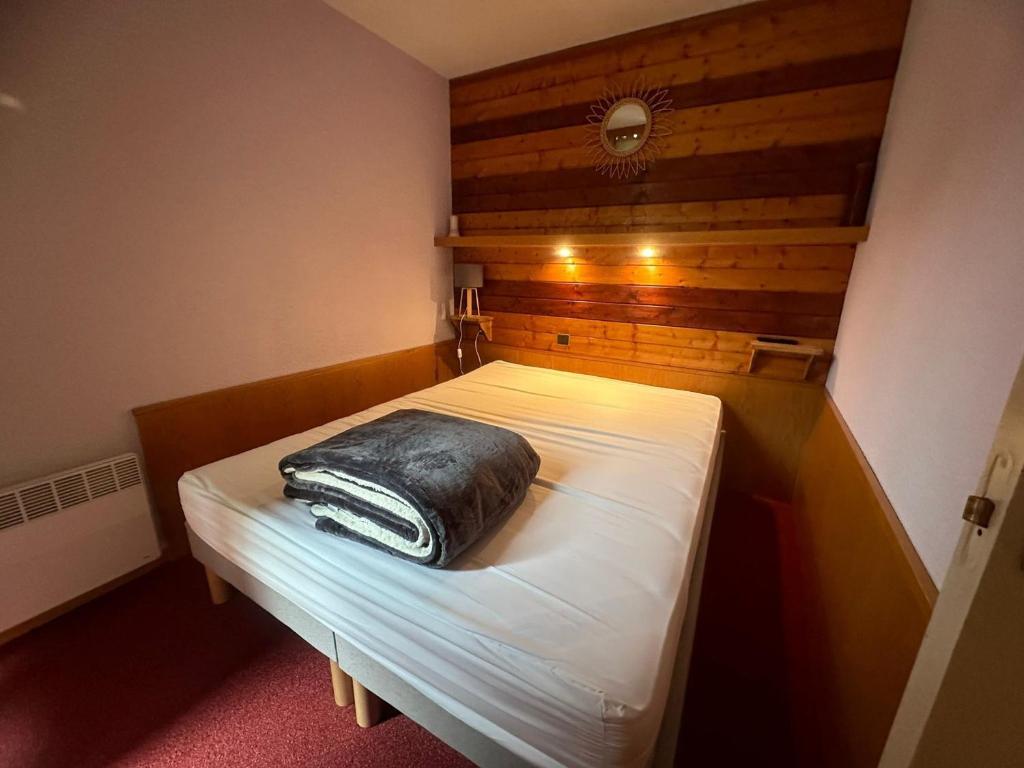 - un lit dans une petite chambre avec un oreiller noir dans l'établissement Appartement 2P 5pers au pied des pistes à Plagne Bellecôte - FR-1-181-2727, à La Plagne Tarentaise