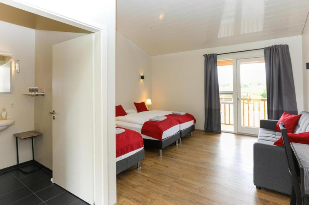 a hotel room with two beds and a couch at Guesthouse Fludir in Fludir