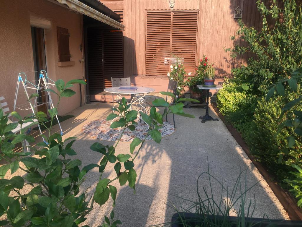 un patio avec une table et des plantes dans l'établissement LE ROSSIGNOL, à Cranves-Sales