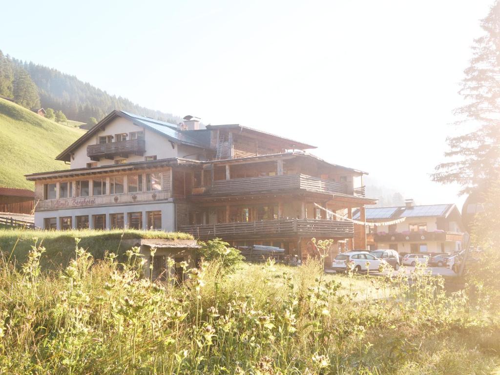 a large wooden house with cars parked in front of it at Almi's Berghotel in Obernberg am Brenner