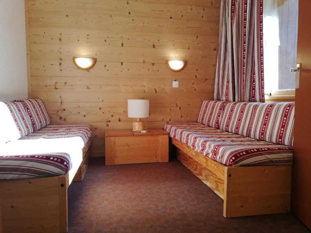 Cette chambre comprend deux lits et une lampe sur une table. dans l'établissement Studio 3 pers, pieds des pistes et ESF, proche commerces - FR-1-356-345, à Valmorel