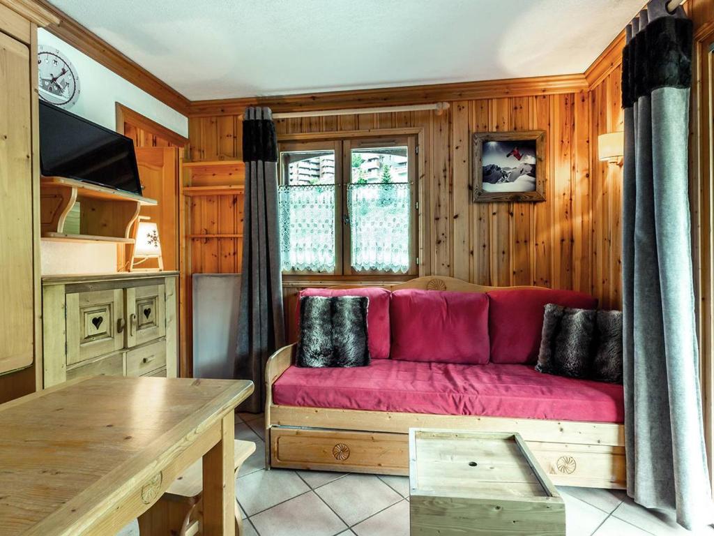 un salon avec un canapé rouge dans une cuisine dans l'établissement Appartement cosy 28m² Méribel Mottaret, 6 pers, proche pistes et commerces, balcon, casier à skis - FR-1-355-9, à Méribel