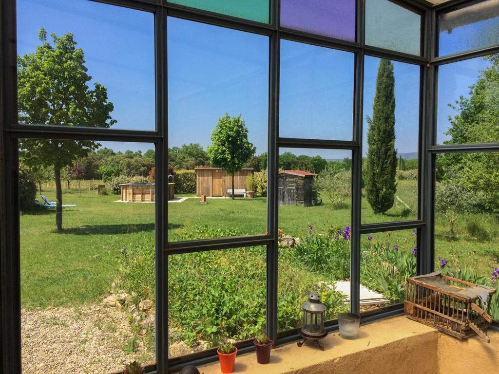 a window view of a garden from a house at 349 Les Maridats in Bédoin