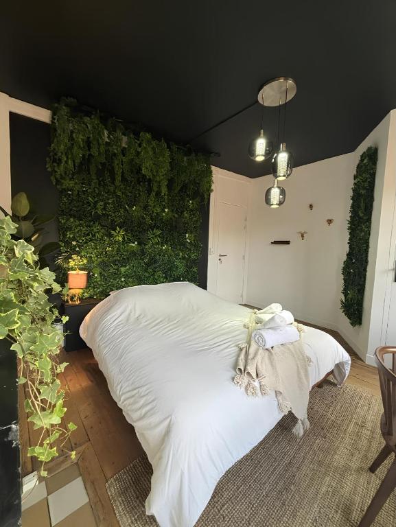 une chambre avec un lit blanc avec un mur vert dans l'établissement L'Oasis Confort, Centre-Ville, à Arras