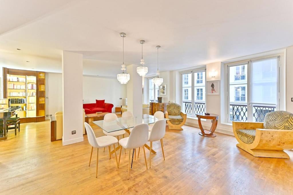 une salle à manger et un salon avec une table et des chaises dans l'établissement Grand Appartement Central Paris 150m2 - II, à Paris