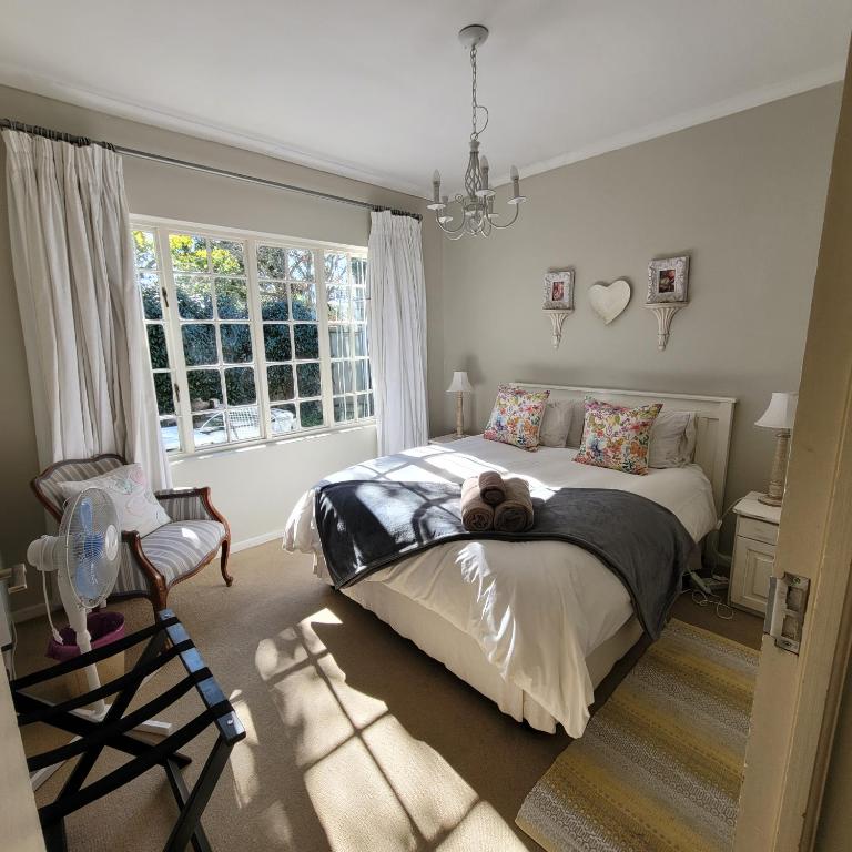 a bedroom with a bed with a teddy bear on it at AppleBee Guest Cottages in Grahamstown