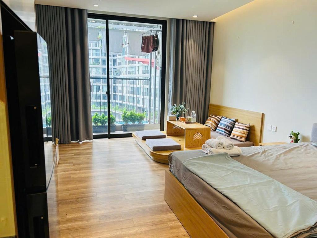 a bedroom with a bed and a large window at Ben's Homestay Ecopark - Landmark L2 in HÆ°ng YÃªn