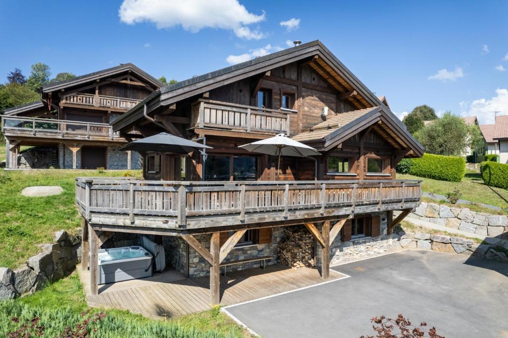 Cette grande maison en bois dispose d'une terrasse. dans l'établissement Chalet 1907, pleine vue lac, à Gérardmer