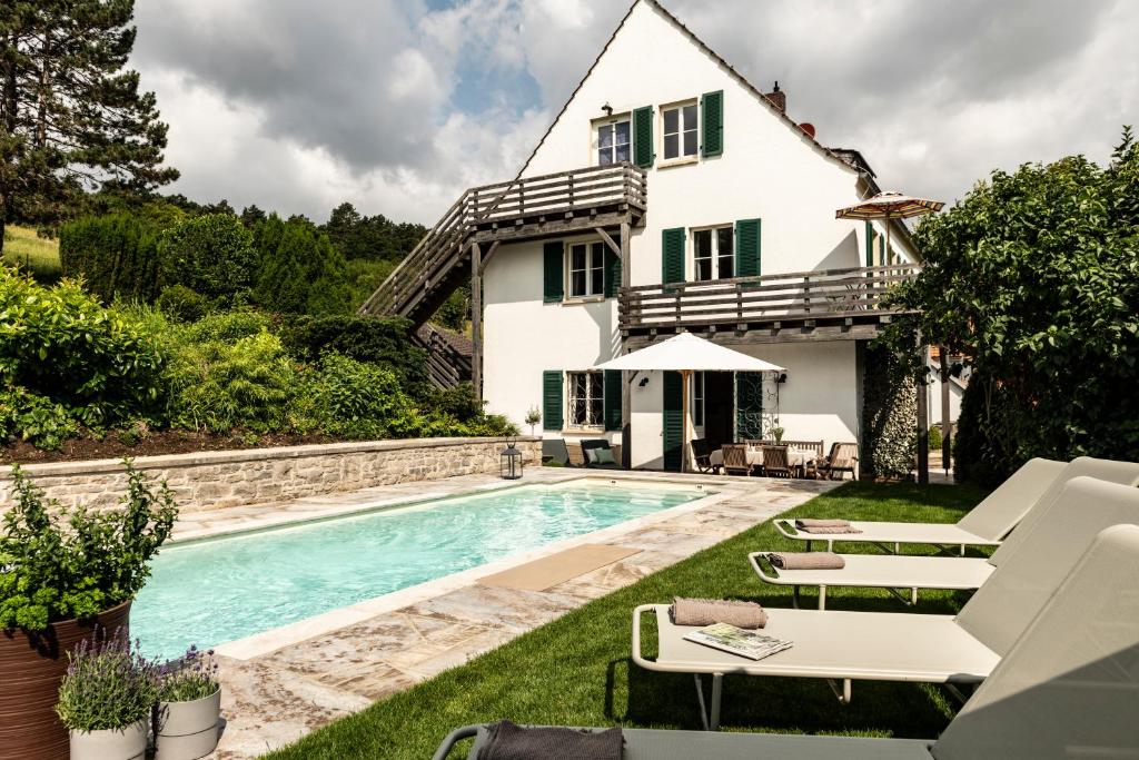 a house with a swimming pool in the yard at Exklusives Ferienhaus in Top Lage mit Pool, Sauna, Terrasse - Der Johannishof in Würzburg