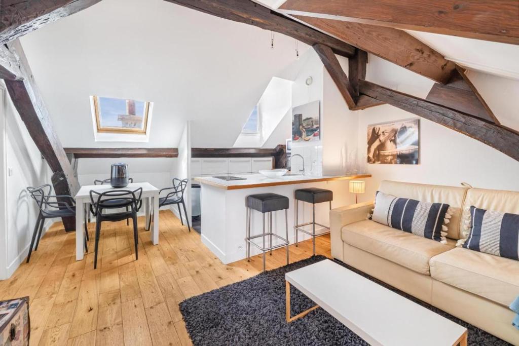 ein Wohnzimmer mit Sofa und Tisch in der Unterkunft Marais Rooftop Apartment in Paris