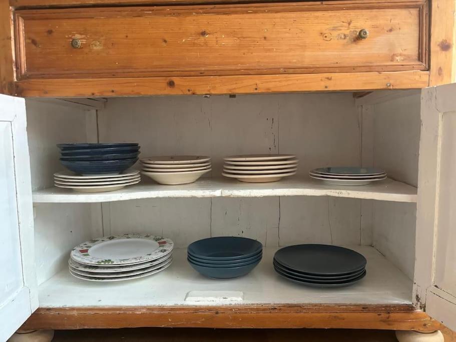 a shelf with plates and bowls in a cabinet at Appartamento la Turrita in Bologna