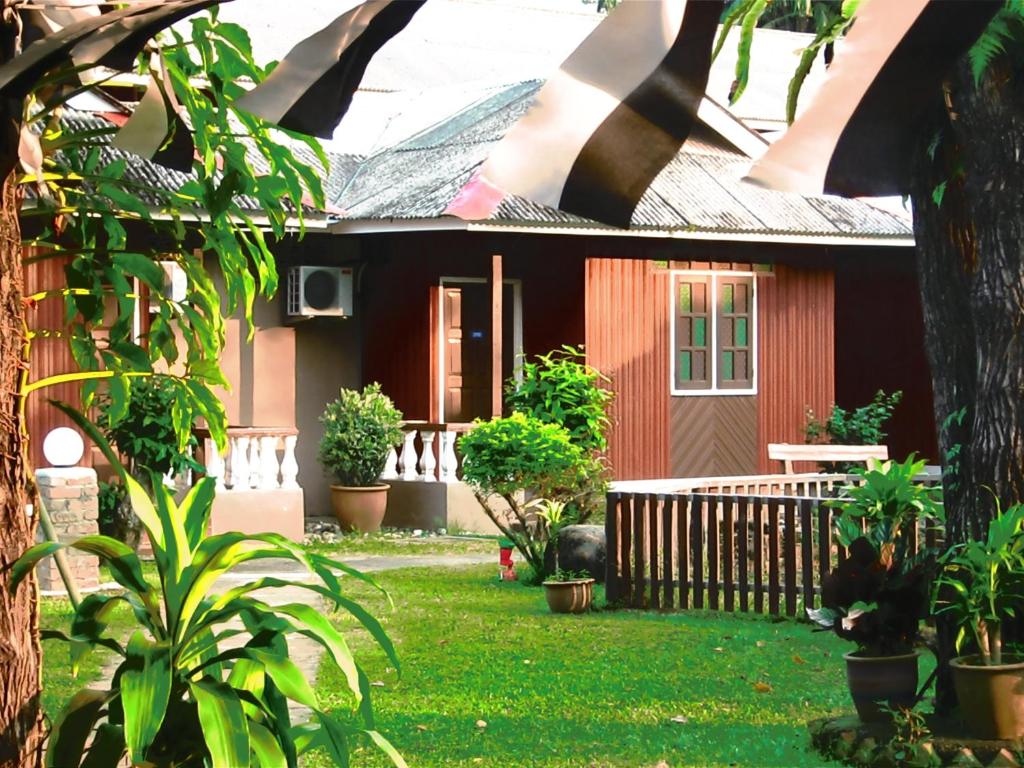a house with a yard with potted plants at Eastana Cherating Beach Resort in Cherating