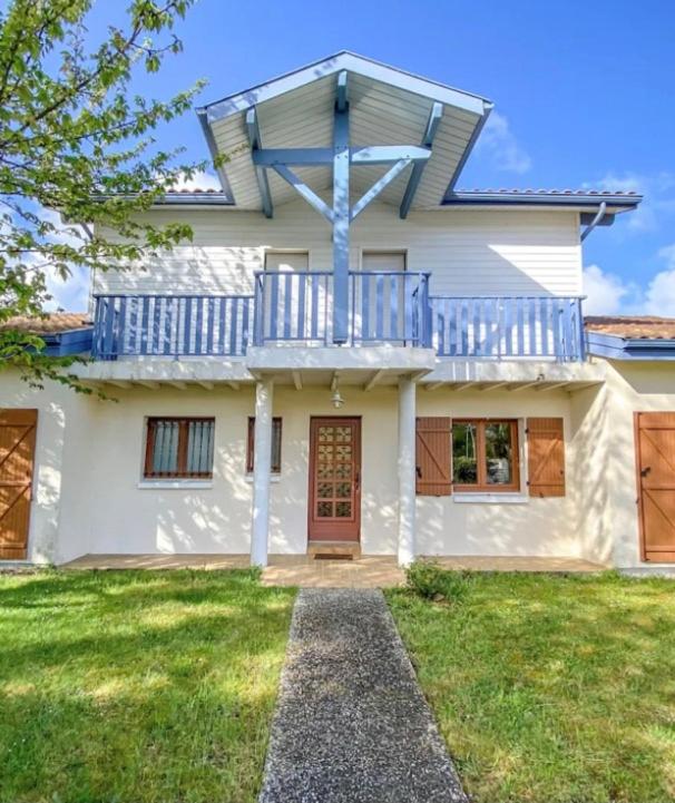 Cette grande maison blanche dispose d'un balcon. dans l'établissement Le Balcon bleu de Biscarrosse, à Biscarrosse