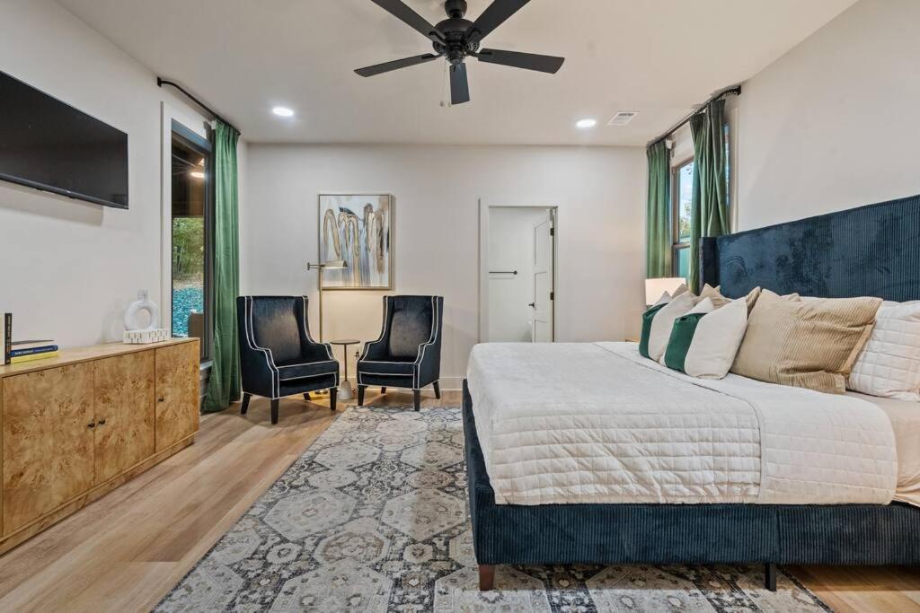 ein Schlafzimmer mit einem Bett und einem Deckenventilator in der Unterkunft Lake Ouachita's Luxury Lake House in Mount Ida