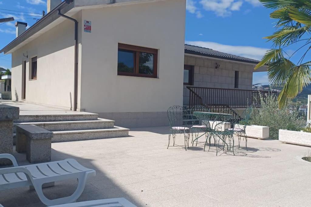 a patio with chairs and tables and a building at Casa Fatinha in Amarante