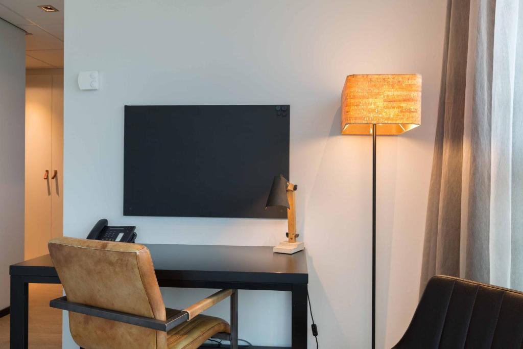 TV a/nebo společenská místnost v ubytování Leonardo Hotel Groningen