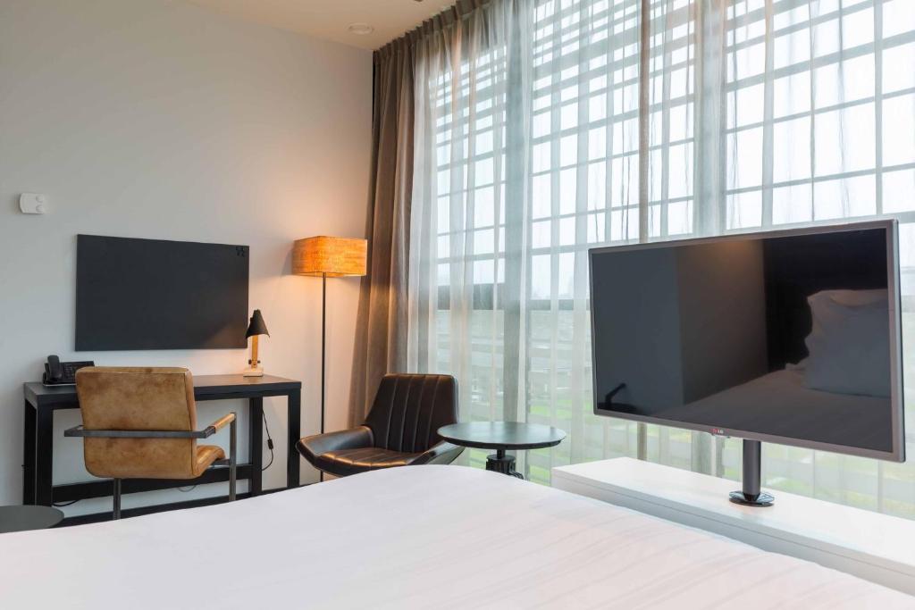 TV a/nebo společenská místnost v ubytování Leonardo Hotel Groningen