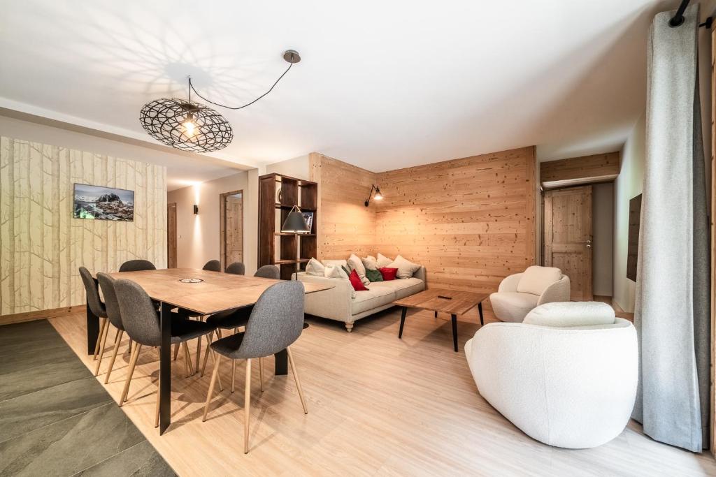 une salle à manger et un salon avec une table et des chaises dans l'établissement CHALET PASCAL A101: 3 chambres + cabine neuf pour 8 personnes, à Morzine