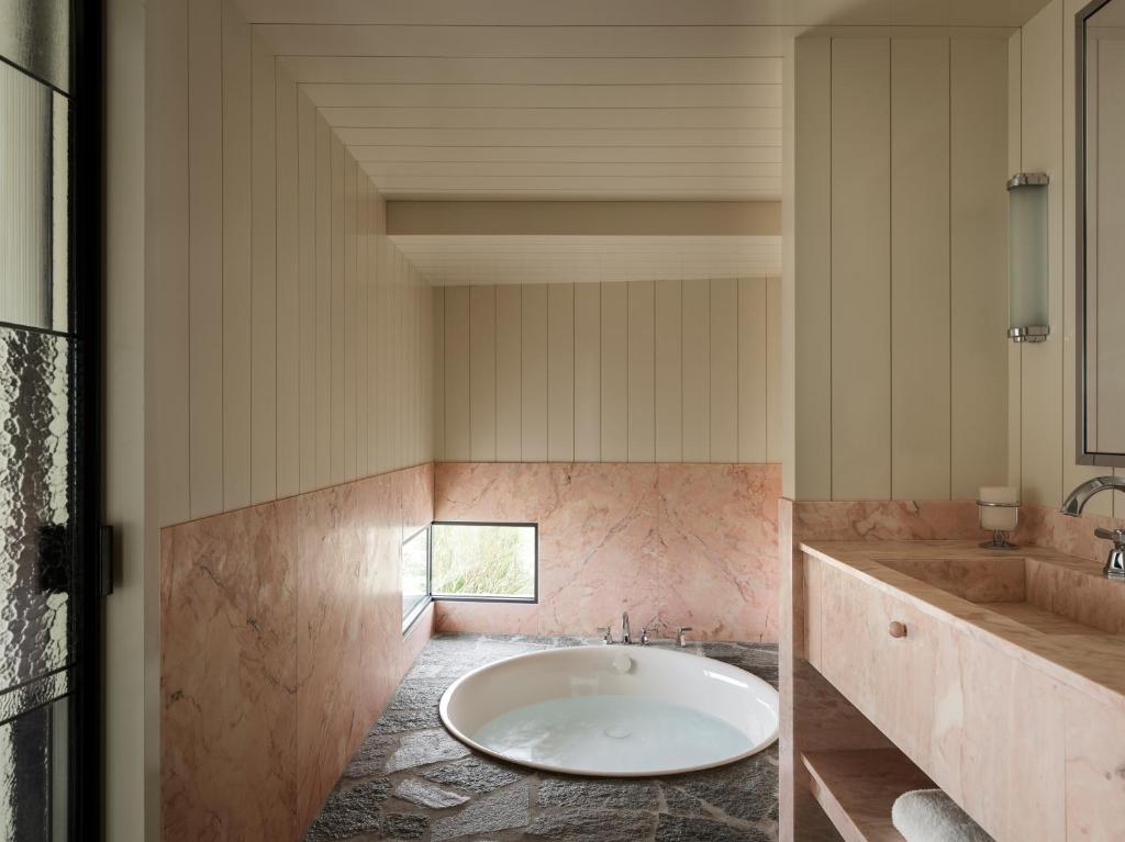 a bathroom with a large tub and a sink at Cap d'Antibes Beach Hotel in Juan-les-Pins