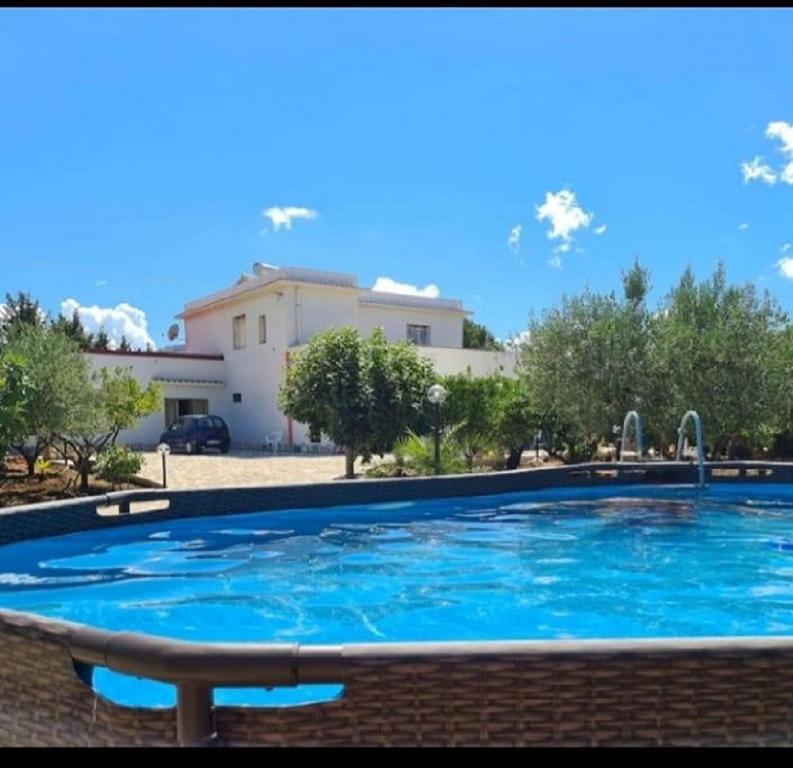 a large blue swimming pool in front of a building at Casa il Sole Casevacanze Ferienwohnung Daniele Furco in Castellammare del Golfo