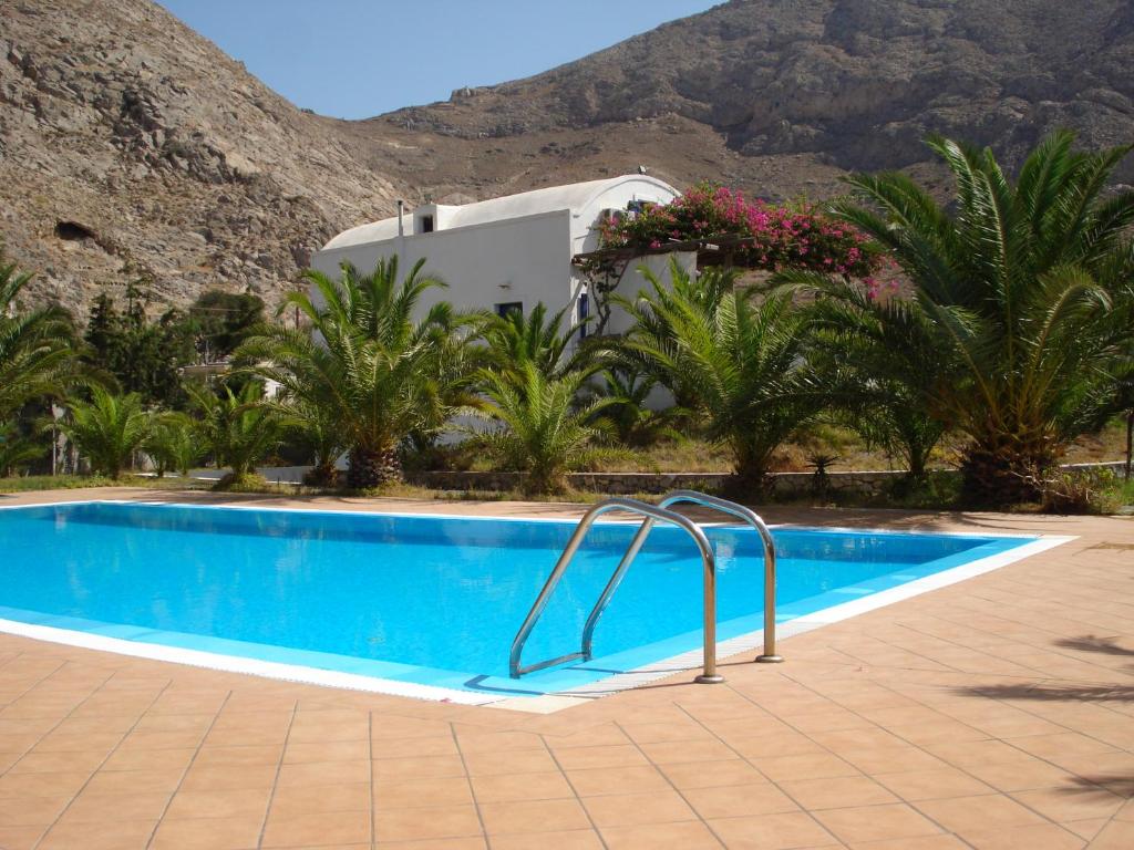 a swimming pool in front of a house with a mountain at HONES - RELAX HOUSE in Perissa