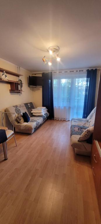 ein Wohnzimmer mit zwei Sofas und einem großen Fenster in der Unterkunft Apartament NELA in Krynica Morska