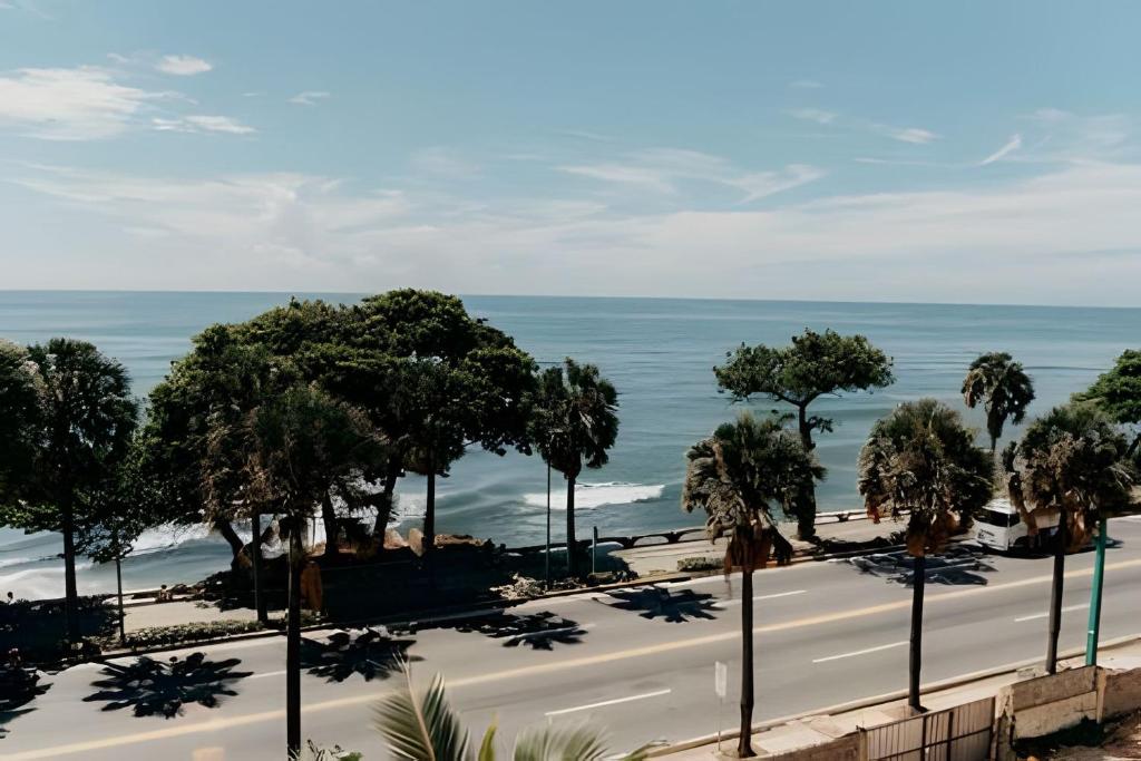 a road with trees and the ocean in the background at Oceanfront 3 Bedroom With Jacuzzi and Pool in Santo Domingo