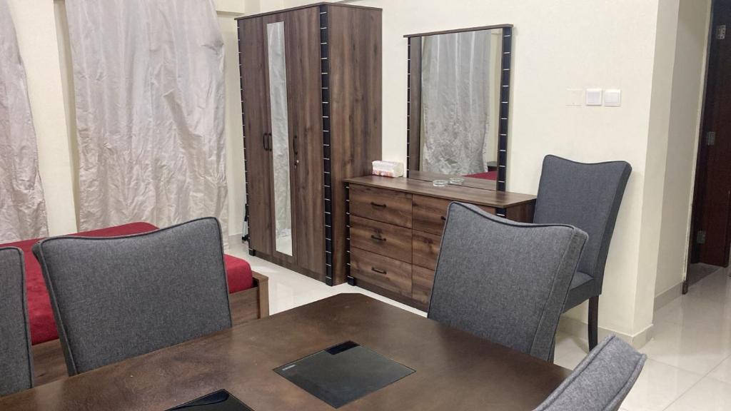 a dining room with a table and chairs and a dresser at Private room for ladies near metro in Dubai