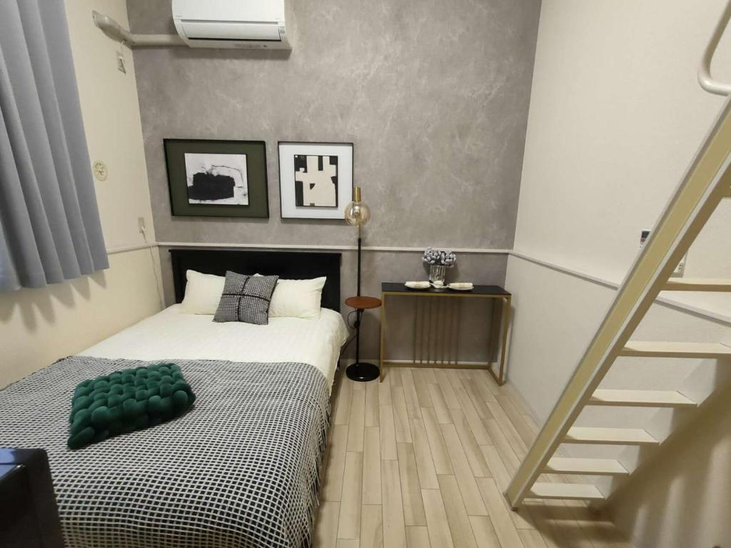 una camera da letto con un letto con un cuscino verde di D12新宿最中心 两室 新大久保站5分-2 rooms Shinjuku center 5 mins to ST Max 4P 新宿 涉谷 表参道 池袋 上野 代代木 银座 原宿 a Tokyo