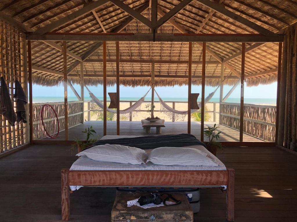 a bed in a room with a view of the ocean at Lar Torus Eco Lodge - Kite is Surf in Tatajuba