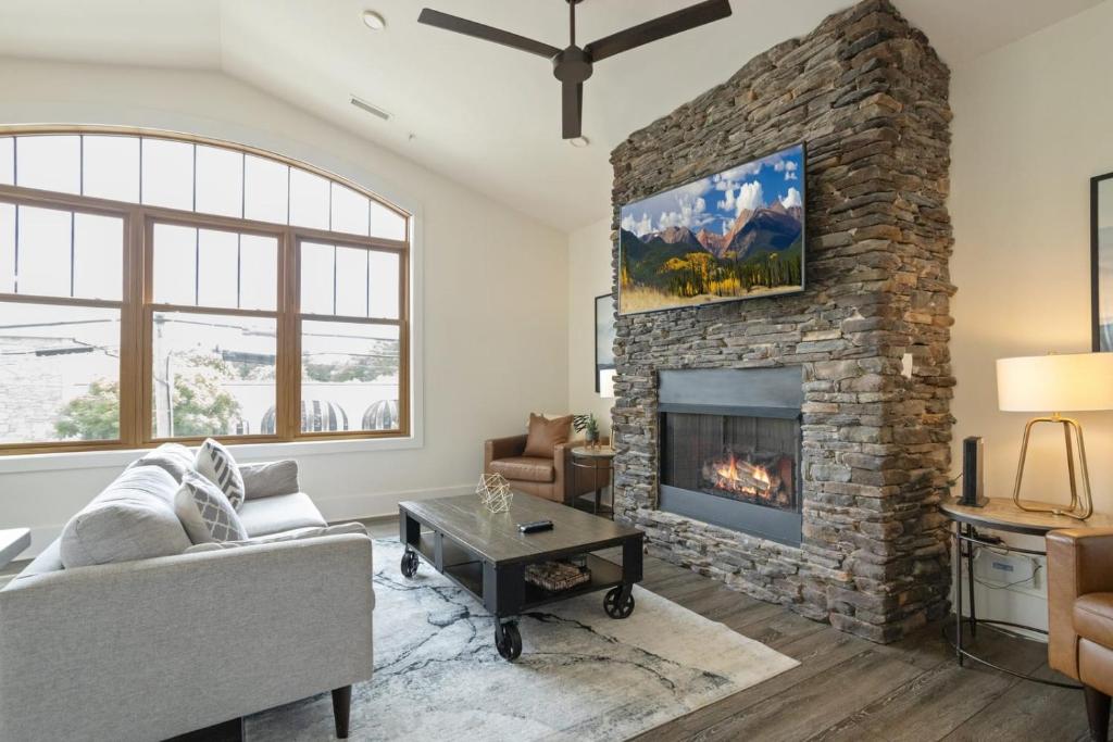 a living room with a stone fireplace at Franklin On Main in Blowing Rock