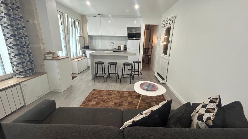 un salon avec un canapé et une cuisine dans l'établissement Bel Appartement a 5 minutes du Louvre, à Paris