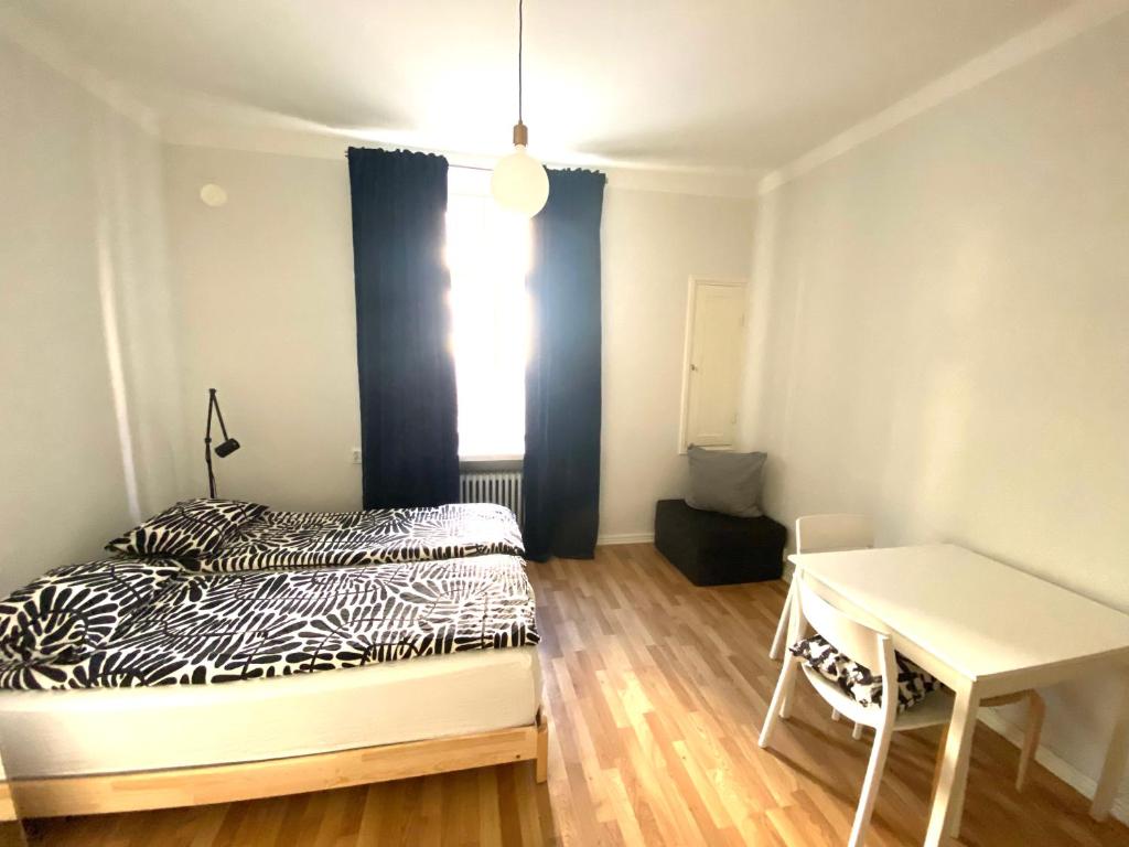 een slaapkamer met een bed, een bureau en een raam bij Simply chic Kamppi FI in Helsinki