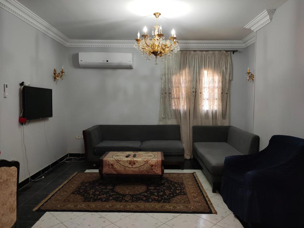 ein Wohnzimmer mit einer Couch und einem Kronleuchter in der Unterkunft فيللا في التجمع الأول in Kairo