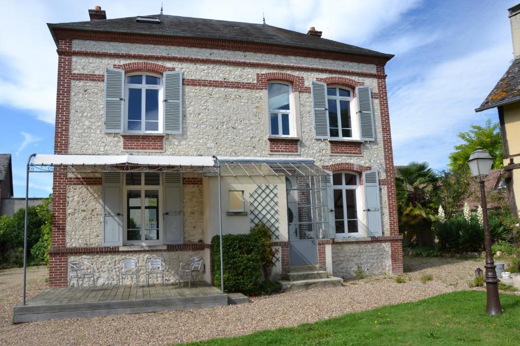 una vecchia casa in mattoni con persiane blu di La ferme aux Hirondelles, proche Giverny a Fontaine-sous-Jouy