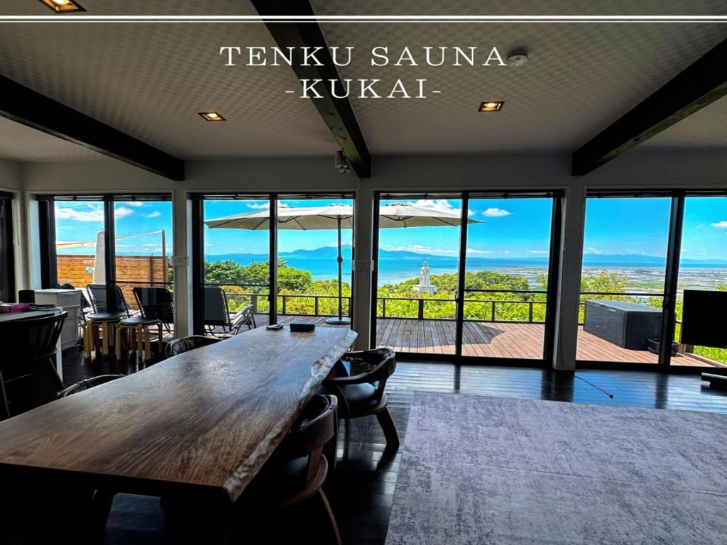 a large wooden table in a room with glass windows at Sky Sauna Kukai - Vacation STAY 97168v in Kumamoto