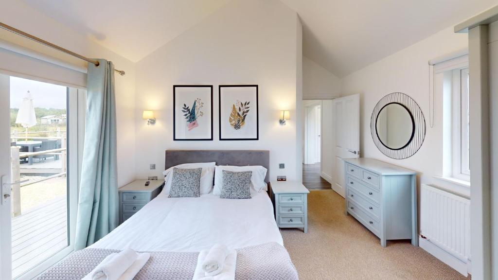 a bedroom with a bed and a large window at Prospect Lodge at The Bay Filey, sleeps up to 6, and 2 dogs stay for free! in Filey