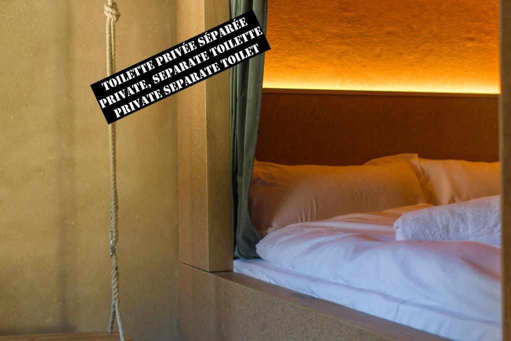 a mirror with a sign on it next to a bed at Peanut Medieval Lodge in Saint-Ursanne