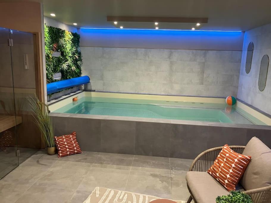 - un salon avec une grande piscine dans l'établissement Villa Kerleven- 150m plage - Spa intérieur-piscine, à La Forêt-Fouesnant
