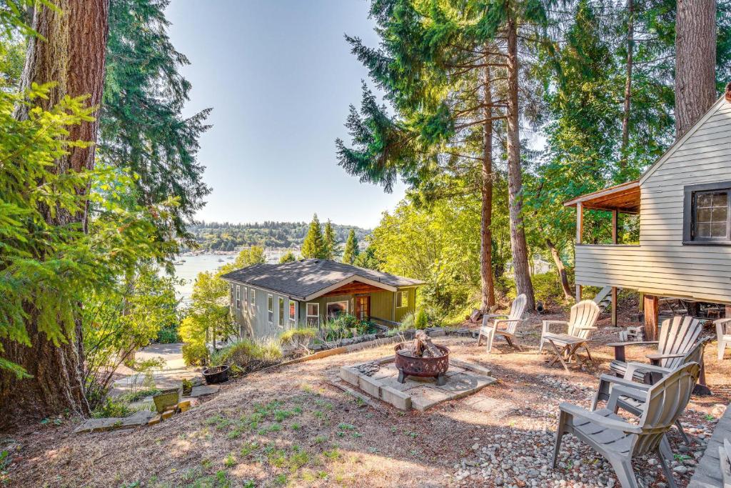 a home in the woods with a fire pit at Gig Harbor Home Large Deck, Outdoor Dining Area in Gig Harbor
