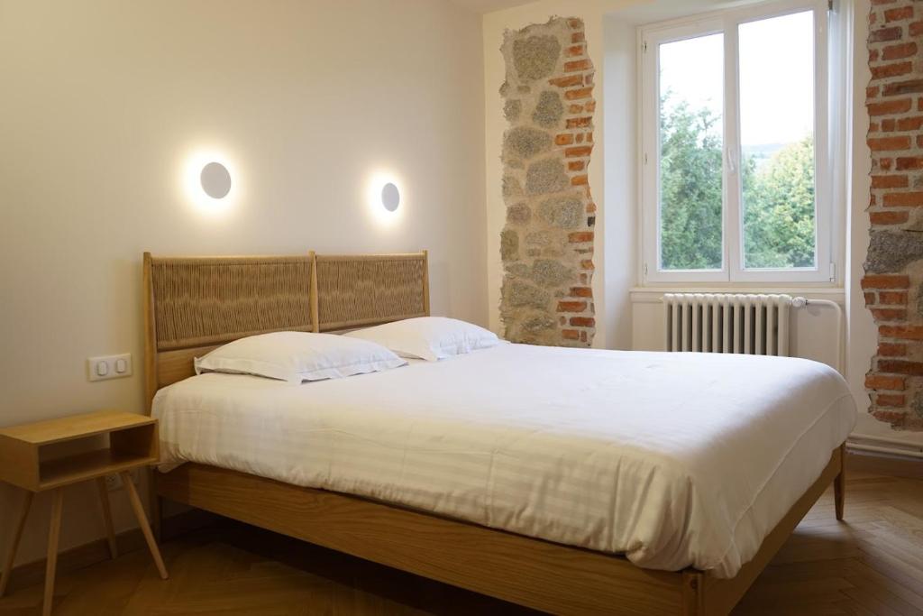 a bedroom with a large bed with white sheets and a window at Hôtel Marchal in Le Hohwald